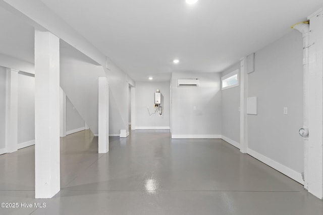 basement featuring recessed lighting, baseboards, an AC wall unit, and water heater