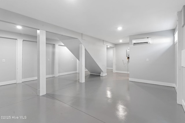 finished basement with recessed lighting, baseboards, stairs, and a wall mounted AC