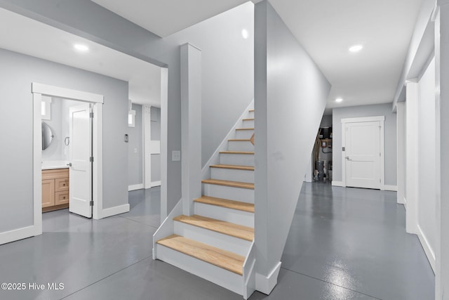 stairway with recessed lighting, finished concrete flooring, and baseboards