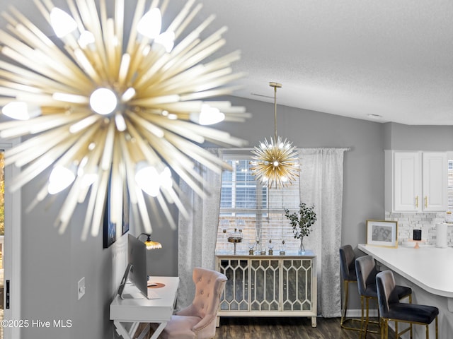 dining space featuring a notable chandelier, a textured ceiling, and vaulted ceiling