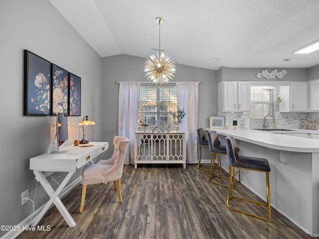 dining room with a notable chandelier, sink, a wealth of natural light, and vaulted ceiling