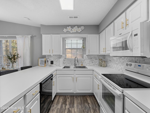 kitchen with plenty of natural light, sink, white cabinets, and white appliances