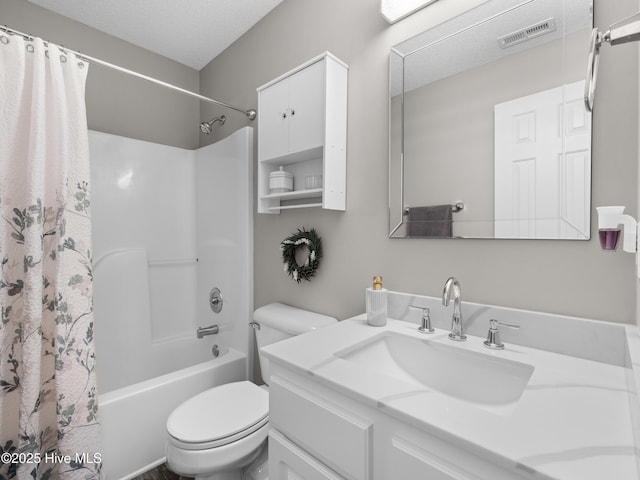 full bathroom with shower / bath combo with shower curtain, vanity, a textured ceiling, and toilet