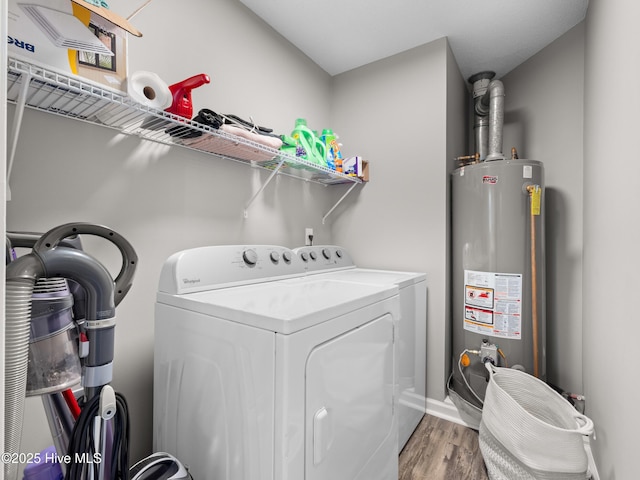 clothes washing area featuring gas water heater, wood-type flooring, and washing machine and clothes dryer