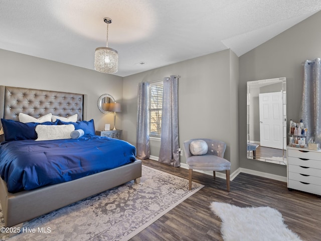 bedroom featuring a textured ceiling, vaulted ceiling, and dark hardwood / wood-style floors