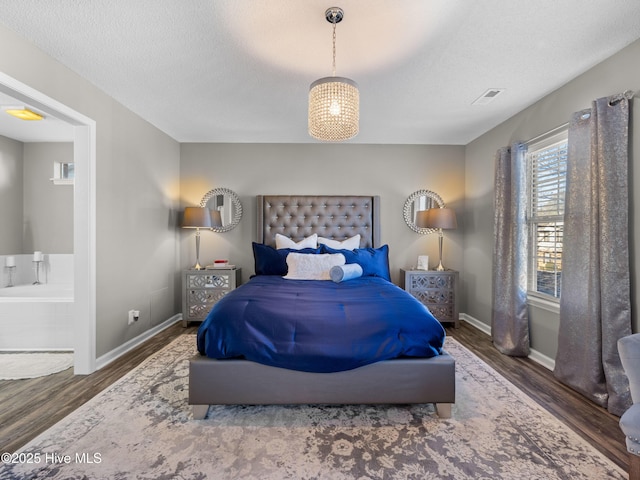 bedroom featuring a textured ceiling and dark hardwood / wood-style flooring