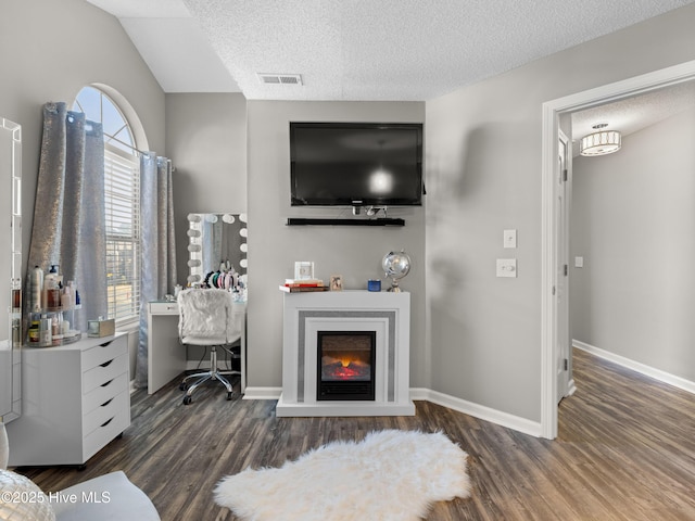 living room featuring dark hardwood / wood-style floors, lofted ceiling, and a textured ceiling