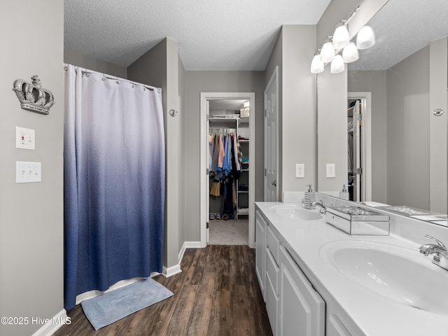 bathroom with vanity, wood-type flooring, a textured ceiling, and walk in shower