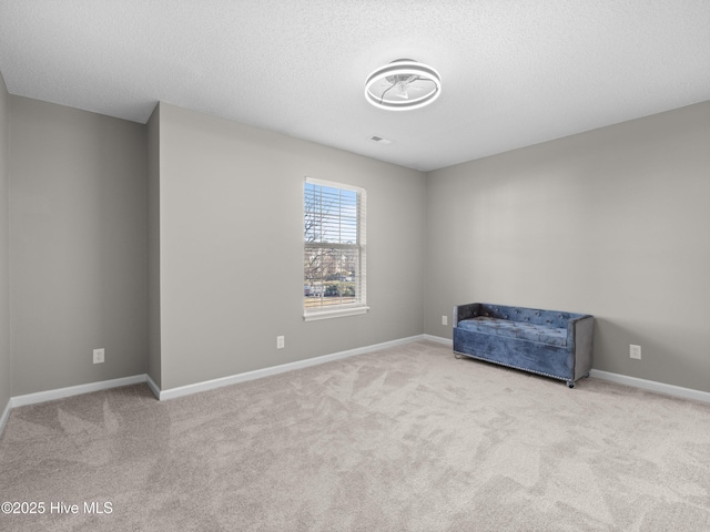 unfurnished room with light carpet and a textured ceiling