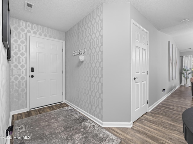 foyer featuring dark hardwood / wood-style floors and a textured ceiling