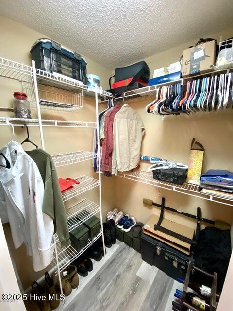 walk in closet with hardwood / wood-style floors