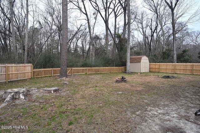 view of yard with a shed and an outdoor fire pit