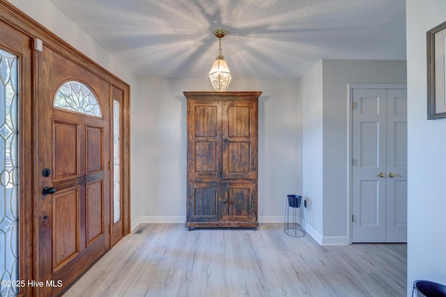 foyer with light hardwood / wood-style floors and a textured ceiling