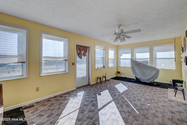 sunroom with ceiling fan and a healthy amount of sunlight