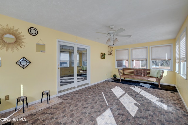 living room featuring ceiling fan, plenty of natural light, and a textured ceiling