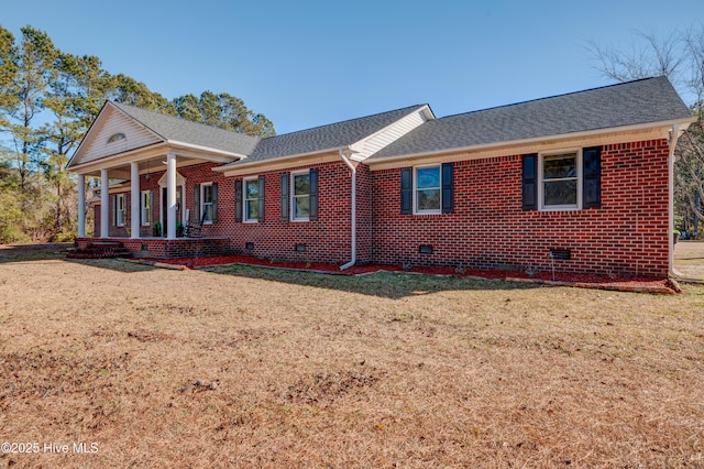 ranch-style home featuring covered porch and a front yard