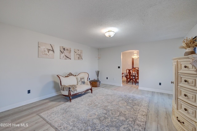 living area with light wood-type flooring and a textured ceiling