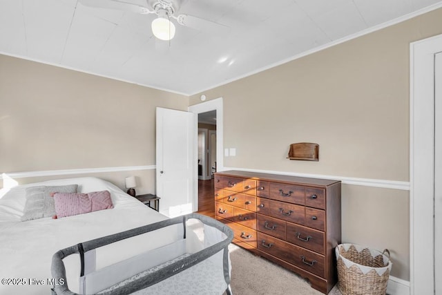 bedroom featuring ceiling fan, ornamental molding, and carpet floors