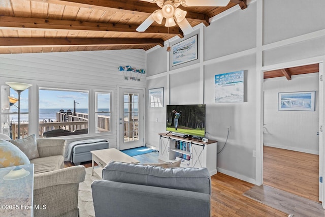 living area featuring light wood-style floors, lofted ceiling with beams, a ceiling fan, baseboards, and wood ceiling