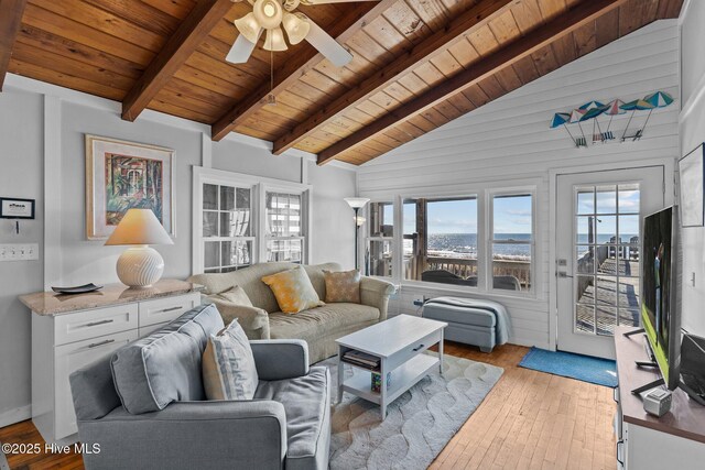living area featuring a ceiling fan, light wood finished floors, vaulted ceiling with beams, and wooden ceiling