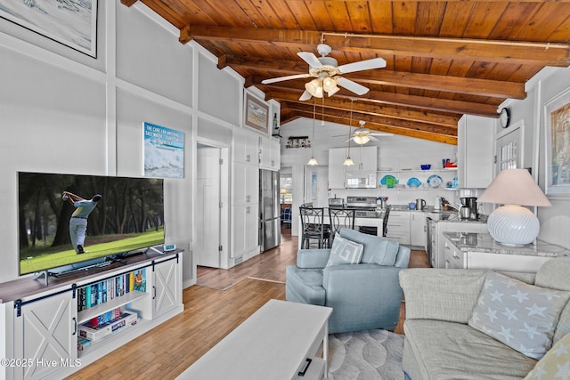 living room with lofted ceiling with beams, light wood-type flooring, a ceiling fan, and wood ceiling