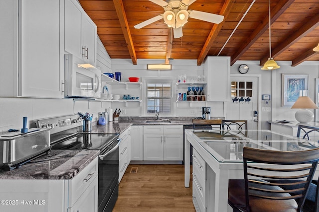 kitchen with wood ceiling, white microwave, open shelves, and stainless steel range with electric cooktop
