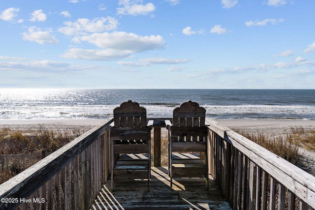 surrounding community featuring a water view and a beach view