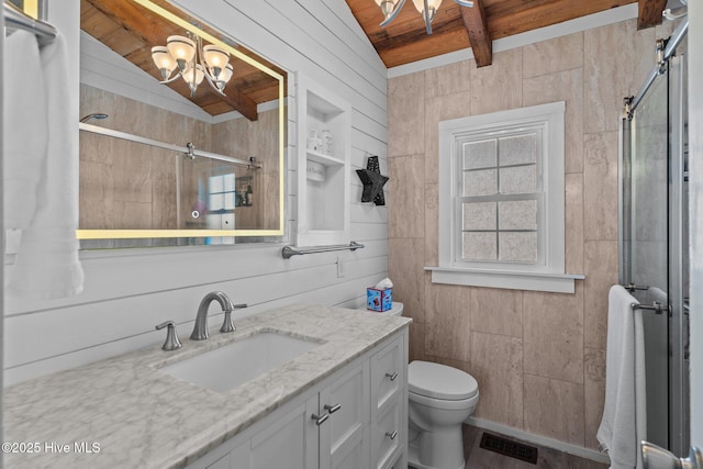 bathroom featuring vanity, toilet, a stall shower, visible vents, and wood walls