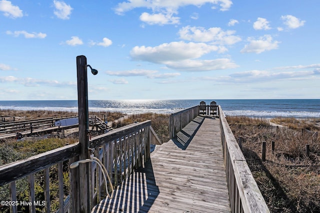 view of home's community featuring a water view and a beach view