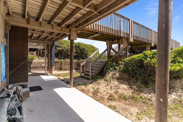 view of patio featuring stairs and fence