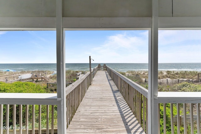 view of property's community with a water view and a view of the beach