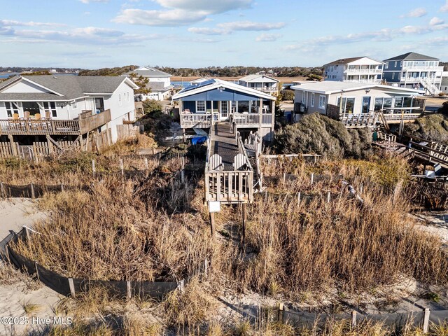 5113 W Beach Dr, Oak Island, NC 28465 - view of front of house featuring crawl space, board and batten siding, and stairway