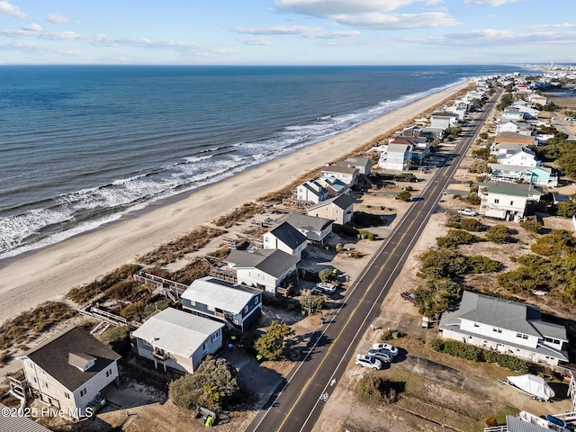 birds eye view of property with a water view and a beach view