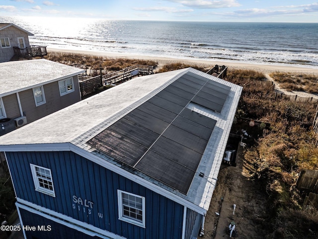 birds eye view of property featuring a water view and a beach view