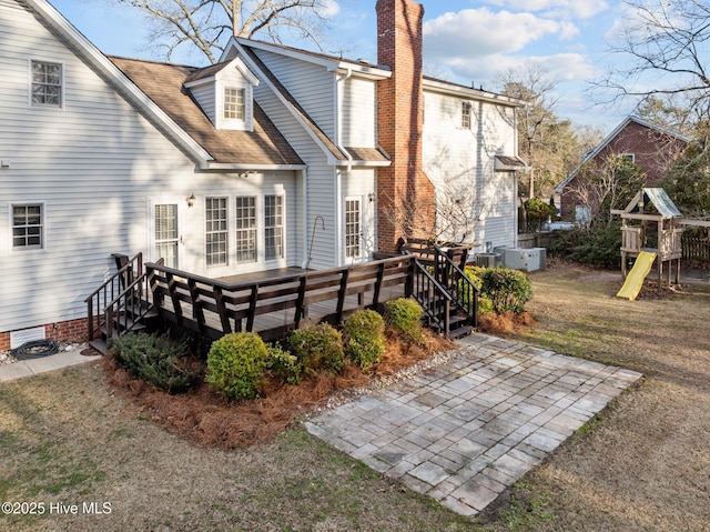 1985 Den Tree Ct, New Bern, NC 28562 - rear view of house featuring a patio, a deck, a playground, a shingled roof, and a chimney