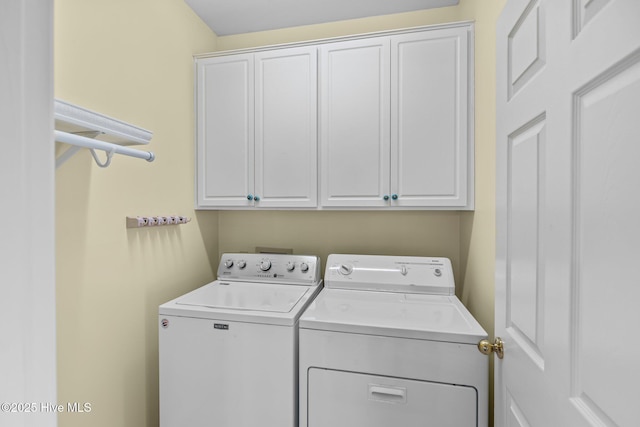 washroom with independent washer and dryer and cabinets