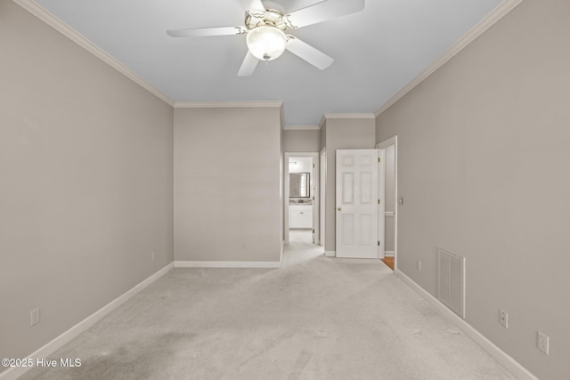 spare room featuring crown molding, light colored carpet, and ceiling fan