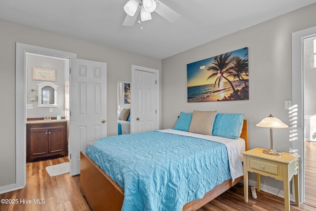 bedroom with connected bathroom, ceiling fan, sink, and hardwood / wood-style flooring