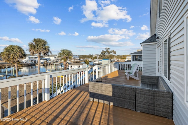 wooden terrace with an outdoor living space and a water view