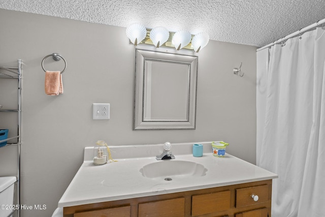 bathroom featuring vanity, a textured ceiling, and toilet