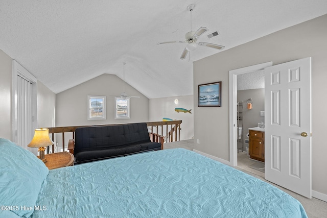 bedroom featuring a textured ceiling, light colored carpet, vaulted ceiling, ceiling fan, and connected bathroom