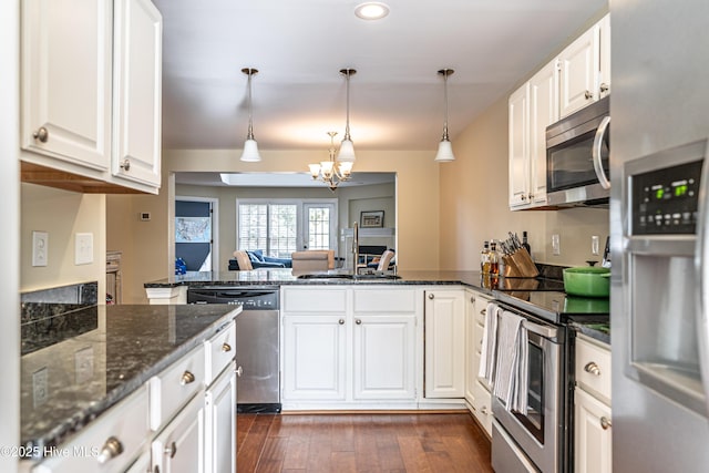 kitchen featuring sink, white cabinetry, a chandelier, pendant lighting, and appliances with stainless steel finishes