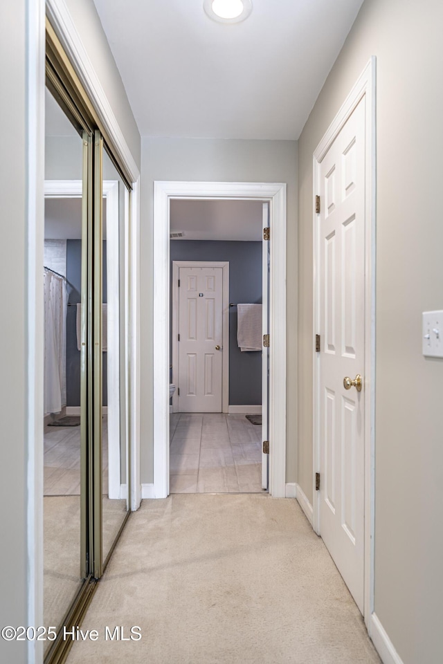 hall with light colored carpet