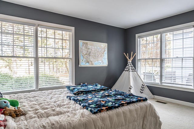 bedroom with carpet flooring and multiple windows