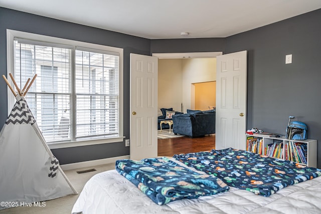 bedroom with carpet flooring and multiple windows