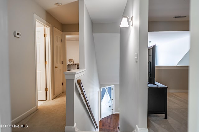 hall featuring light colored carpet