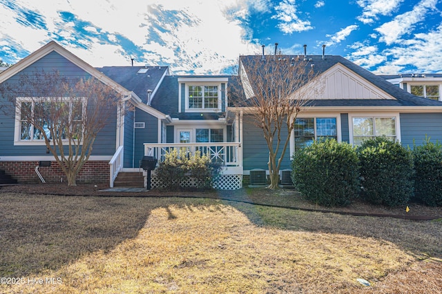 view of front of property with central air condition unit, a front lawn, and a wooden deck