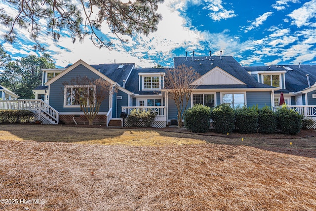 view of front of house with a wooden deck and a front lawn