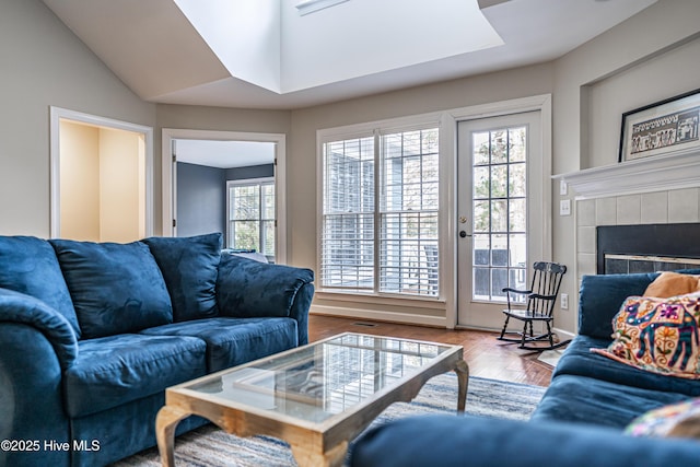 living room with a healthy amount of sunlight, a fireplace, and hardwood / wood-style flooring