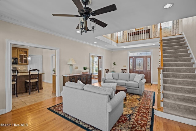 living room featuring crown molding, ceiling fan, and light hardwood / wood-style flooring